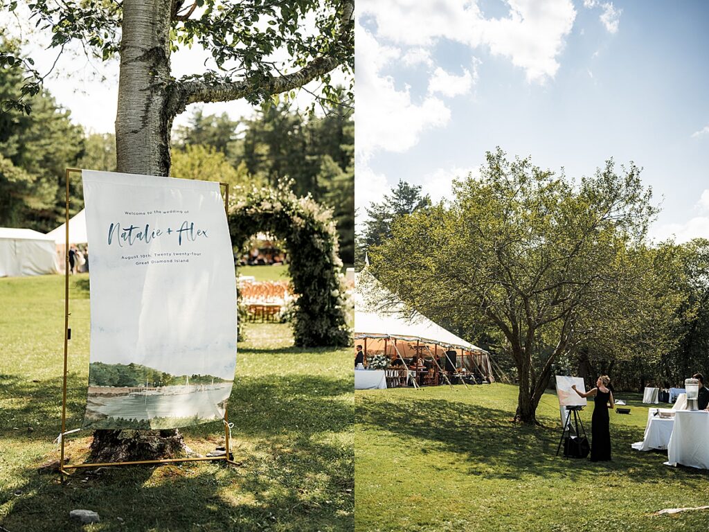 Wedding welcome sign displayed on fabric beneath a tree and live painter creating artwork on the lawn at Inn at Diamond Cove in Maine.