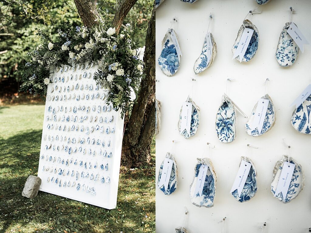 Oyster shell escort cards with blue patterns arranged on a display board with greenery.