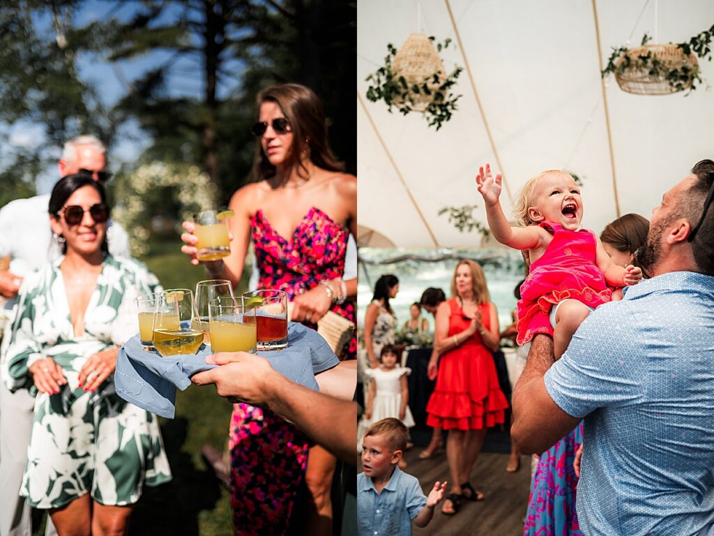 Guests holding drinks outdoors and a child lifted in the air during the reception at Inn at Diamond Cove in Maine.