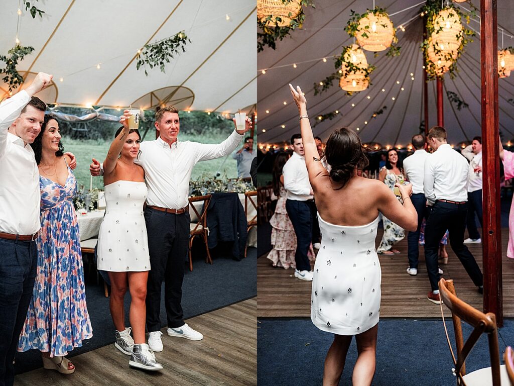 Guests raising drinks and dancing under string lights inside a sailcloth tent reception at Inn at Diamond Cove in Maine.