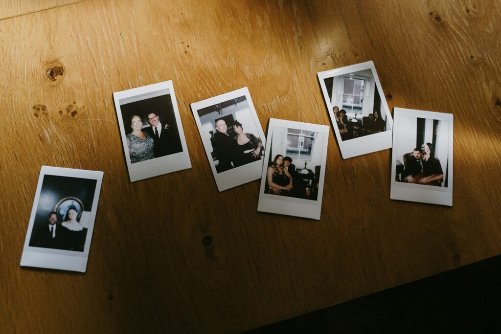 Collection of instant photos scattered across a wooden table.