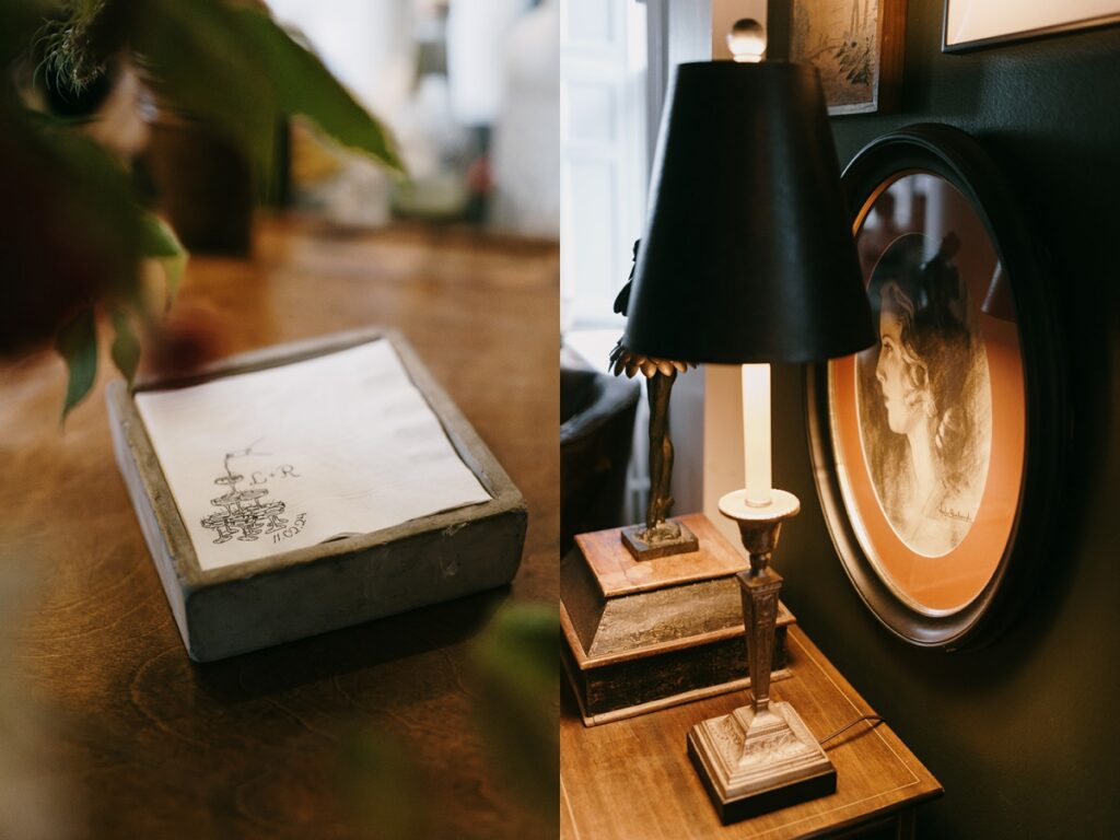 Left: Stack of cocktail napkins with custom monogram and date on a wooden table. Right: Vintage lamp and framed portrait on a wooden side table with warm lighting.