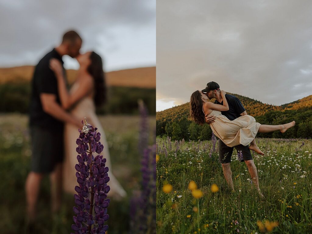 Close-up of engagement ring on a lupine flower with the couple kissing blurred behind it and the man lifting the woman in a mountain meadow.