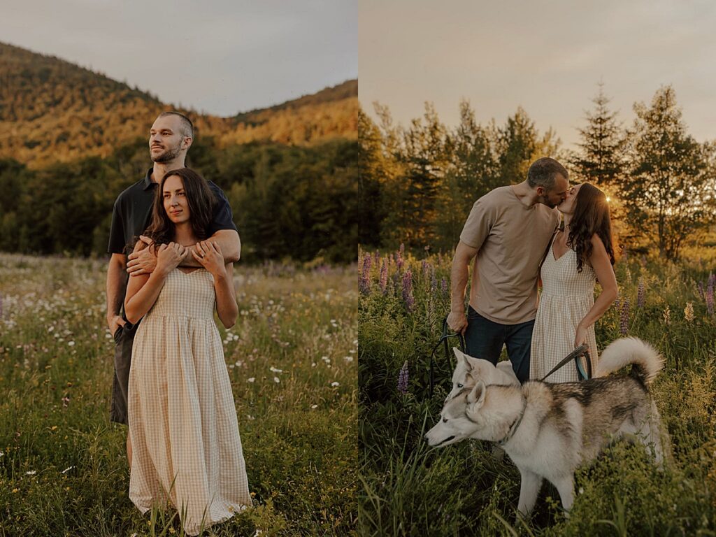 Couple standing together in a mountain meadow and kissing beside their husky dogs at sunset during a New Hampshire engagement session.