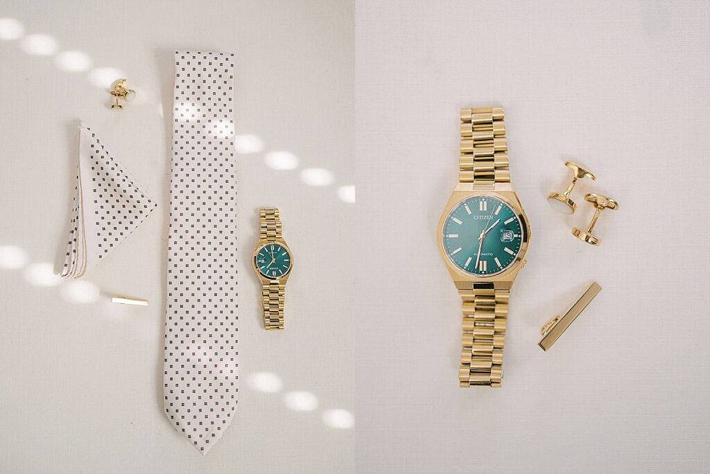 Groom accessories including tie, pocket square, cufflinks, tie bar, and gold watch styled on light surface.