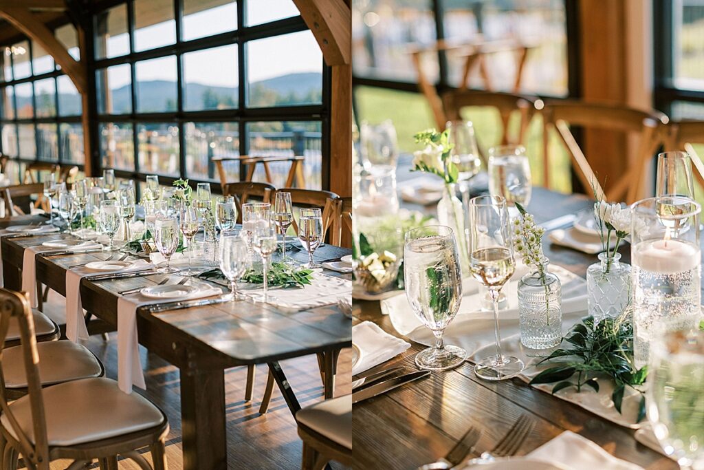 Long wooden reception tables set with glassware, candles, and greenery inside a bright reception hall.