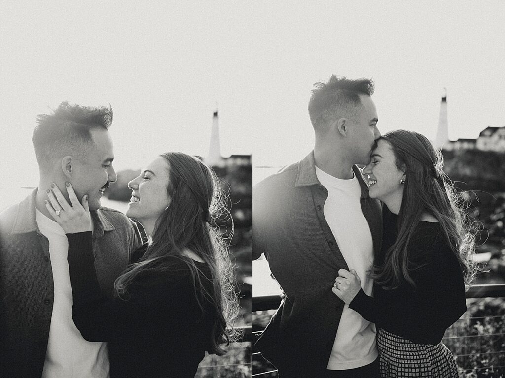 Black and white portraits of newly engaged couple smiling and embracing with lighthouse softly visible behind them.