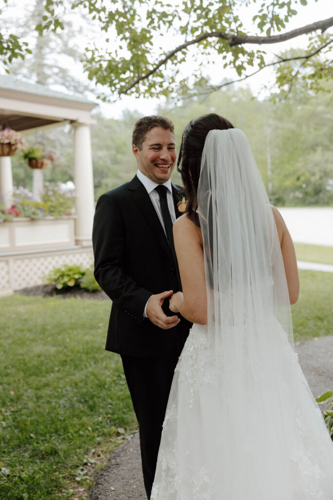 Groom turning toward bride during first look outdoors, candid wedding moment