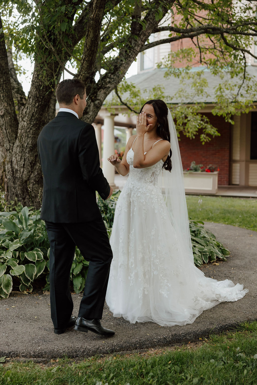 Bride reacting emotionally during first look with groom in garden setting